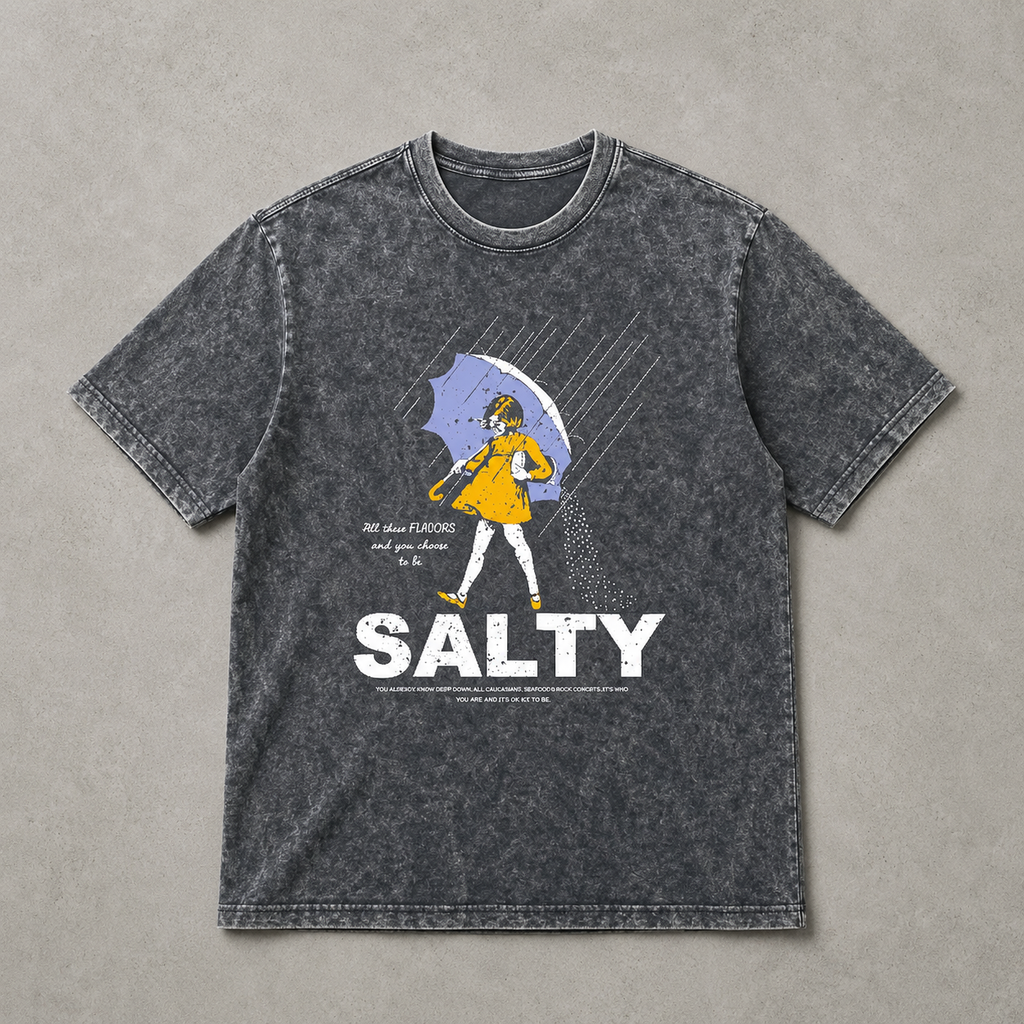 Gray t-shirt with graphic design and 'Salty' text on a concrete surface