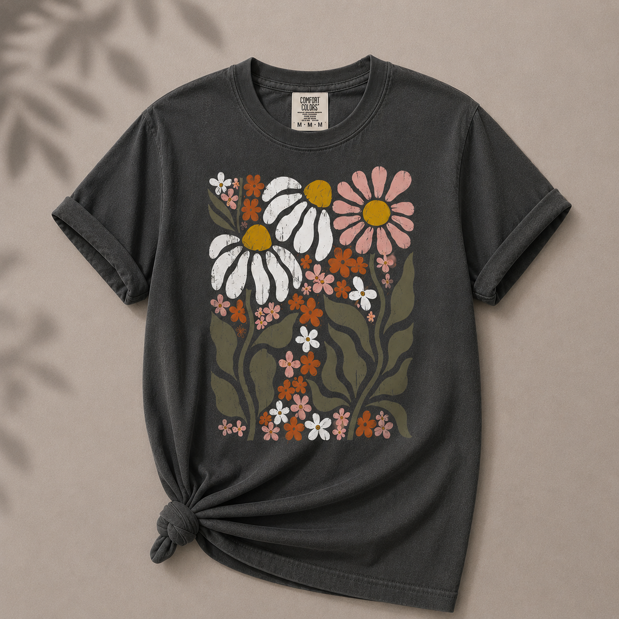 Black t-shirt with floral design on a beige background