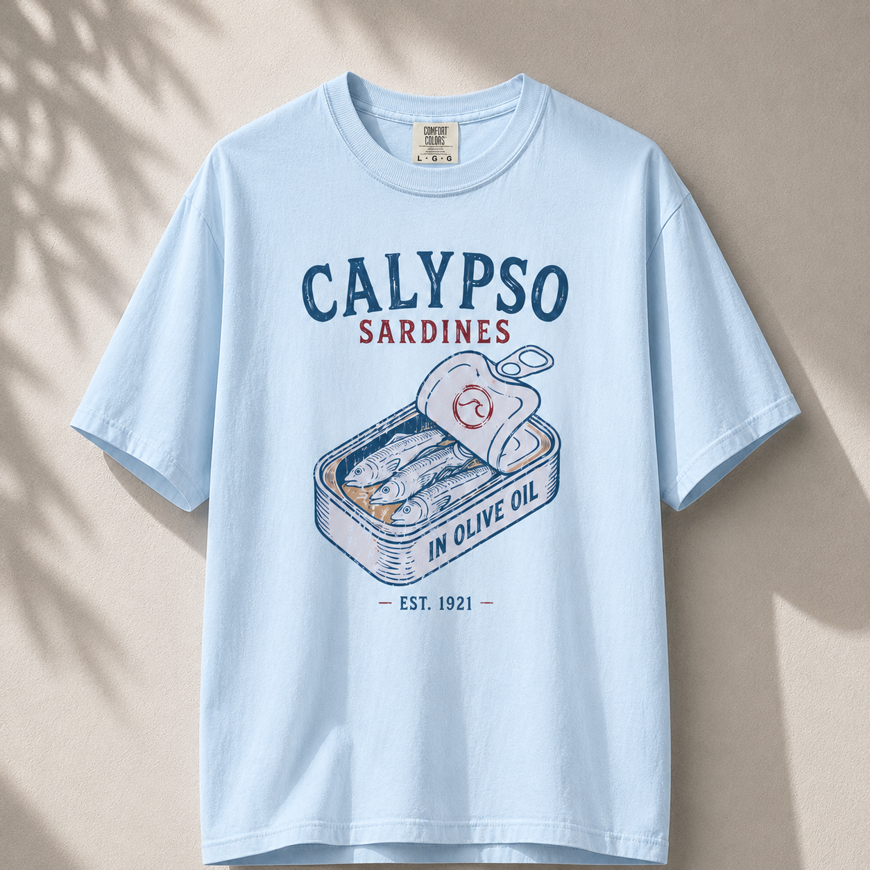 Light blue t-shirt with 'Calypso Sardines' graphic on a beige background