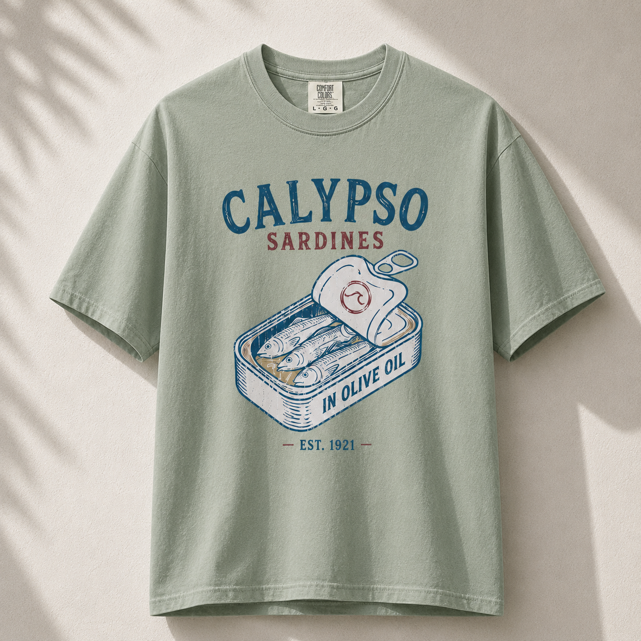 Green t-shirt with Calypso Sardines graphic on a beige background