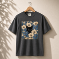 Black t-shirt with a floral pattern and black cat design on a beige background