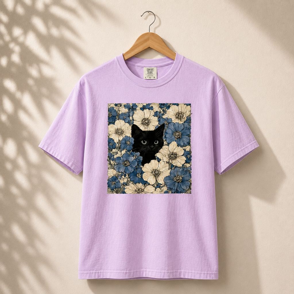 Lavender t-shirt with a black cat and floral design on a beige background