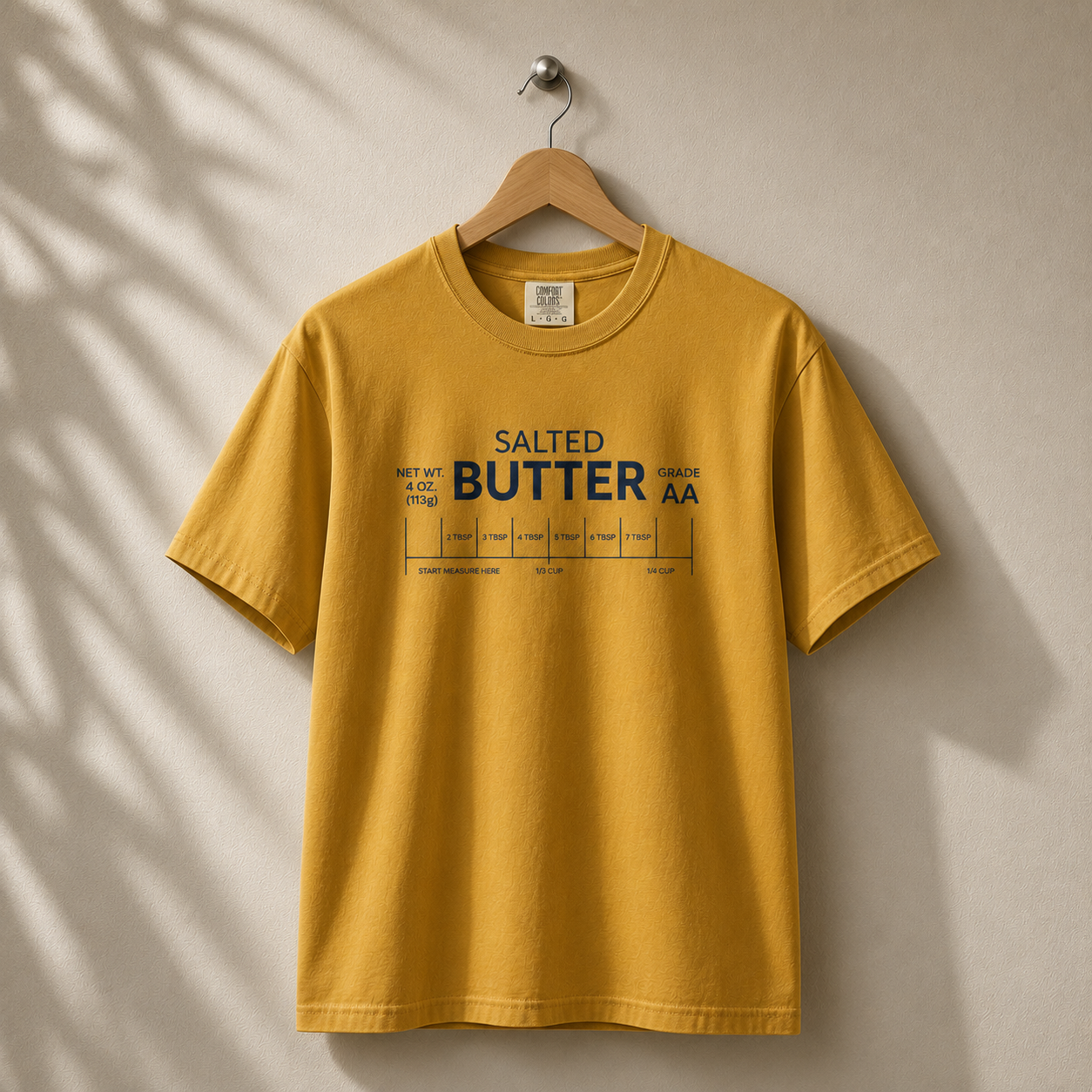Yellow t-shirt with 'Salted Butter AA' text on a beige background