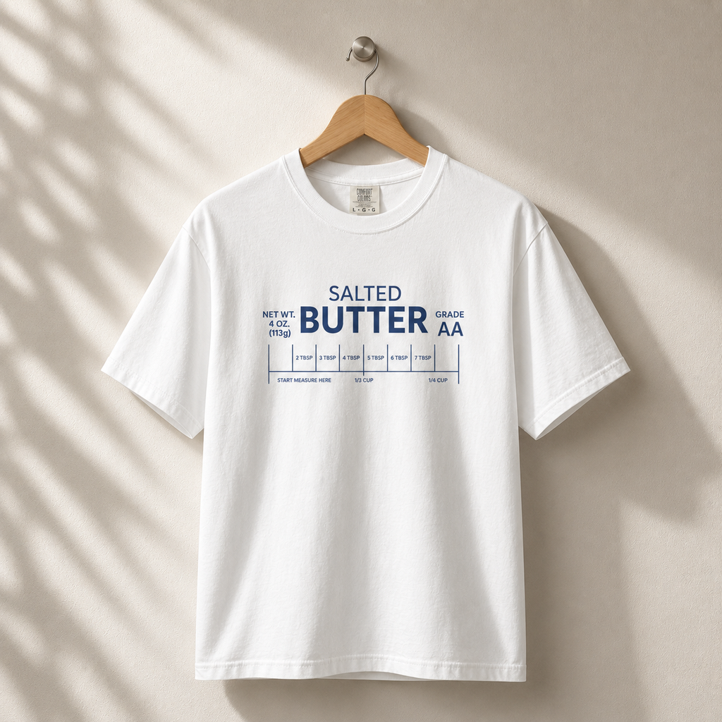 White t-shirt with 'SALTED BUTTER AA' text on a beige wall