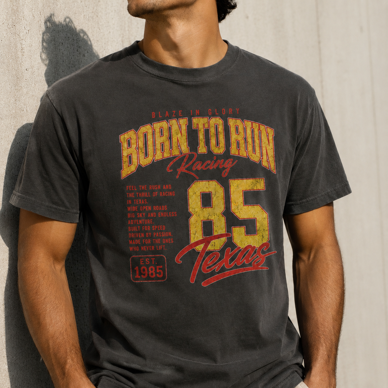 Person wearing a black t-shirt with 'Born to Run Racing 85 Texas' text design.
