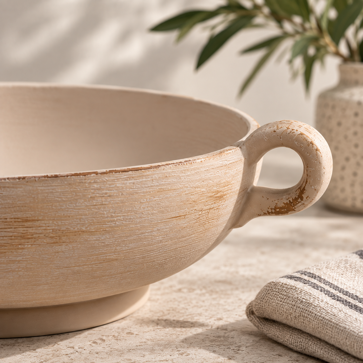 Close-up of distressed stoneware bowl loop handle and textured finish