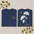 A navy blue crewneck sweatshirt shown flat from both front and back on a light beige background with decorative ginkgo leaves. The front features a gold 'F N H' monogram with wheat stalks.
