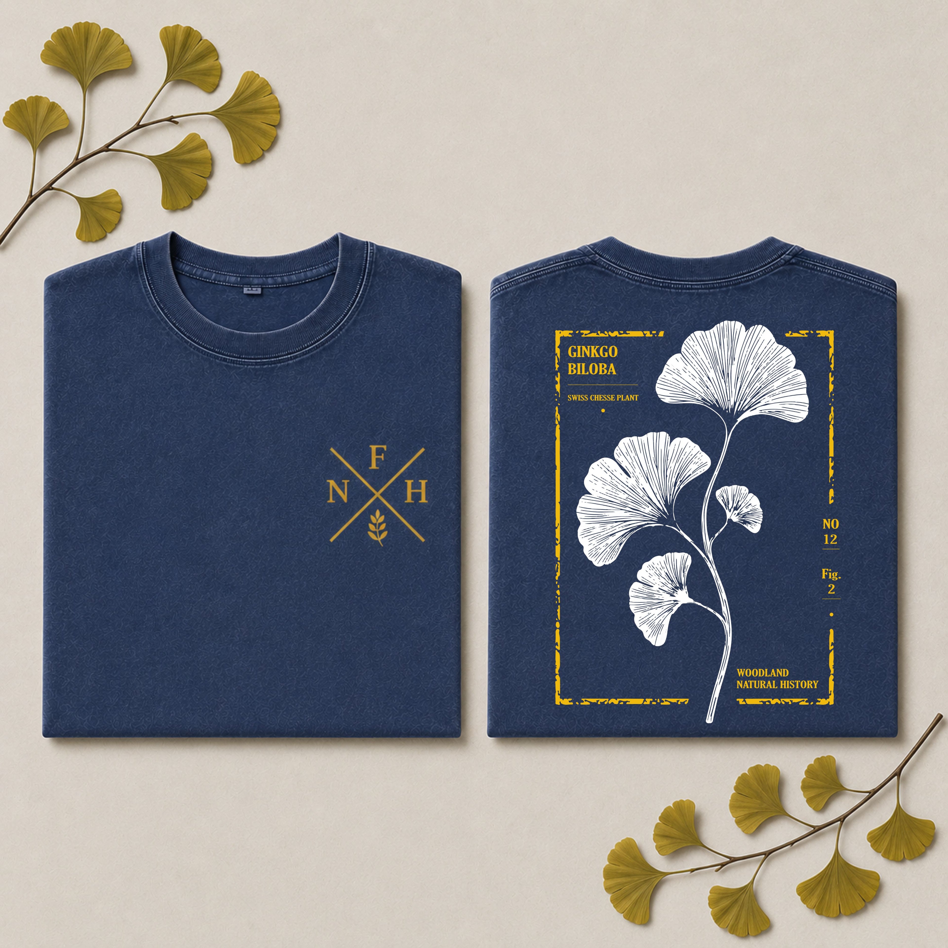 A navy blue crewneck sweatshirt shown flat from both front and back on a light beige background with decorative ginkgo leaves. The front features a gold 'F N H' monogram with wheat stalks.