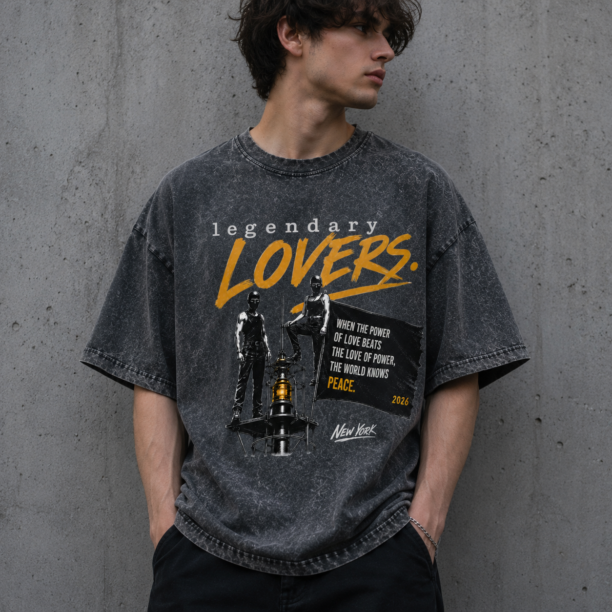 Lifestyle mockup of a man wearing the Legendary Lovers oversized snow washed t-shirt in Pirate Grey featuring a bold vintage grunge graphic with yellow typography, peace quote and New York artwork. Unisex streetwear oversized tee.