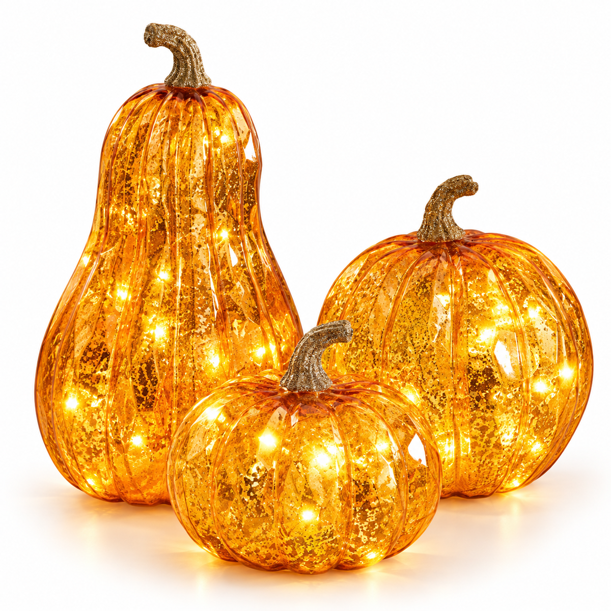 Set of three lighted orange mercury glass pumpkins on a white background