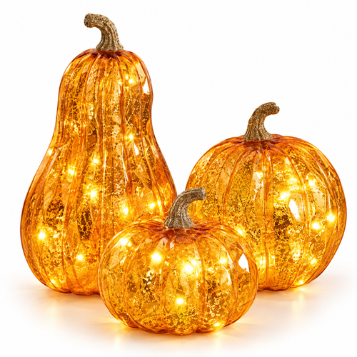 Set of three lighted orange mercury glass pumpkins on a white background