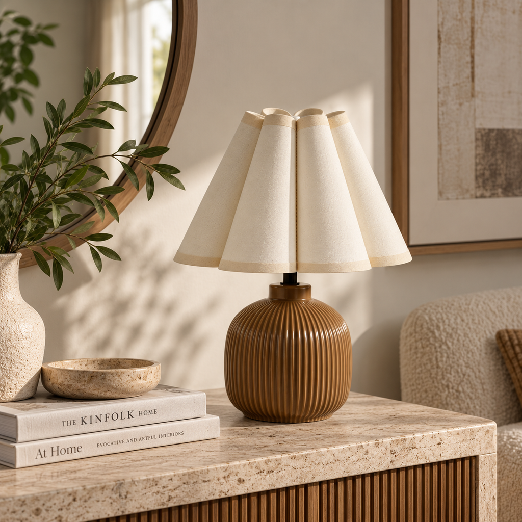 Scalloped ceramic accent lamp styled on a stone console in a bright neutral living room