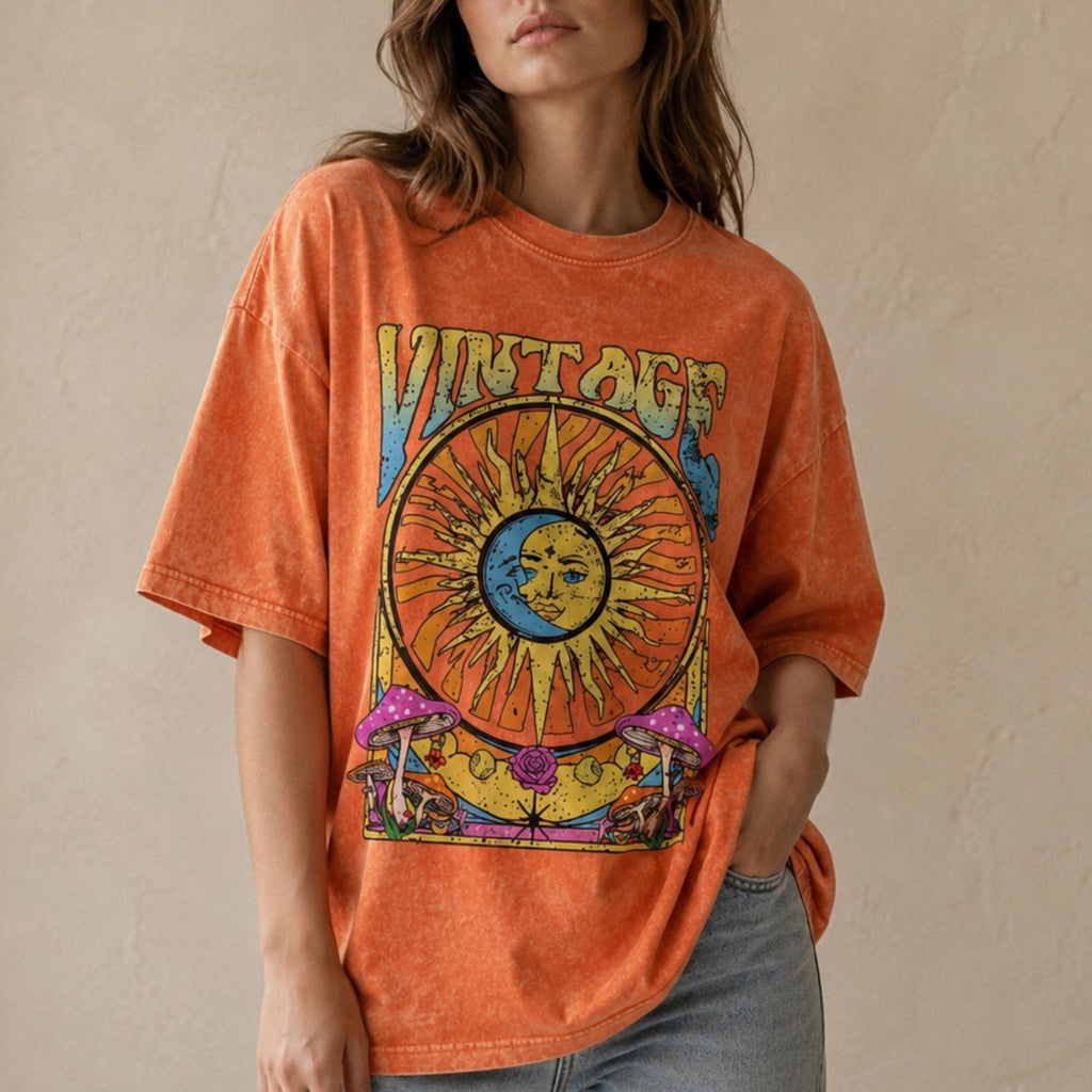 Woman wearing an orange vintage washed oversized t-shirt with celestial sun and moon graphic
